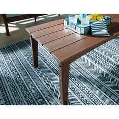 a wooden table sitting on top of a blue rug