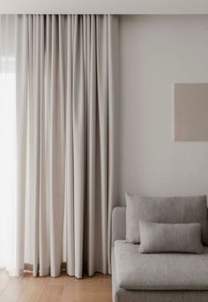 a living room with white walls and curtains