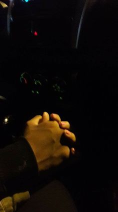 two people sitting in the passenger seat of a car with their hands on each other