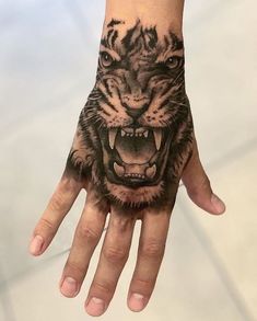 a hand with a tiger tattoo on it