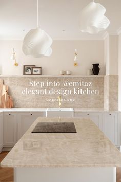 a kitchen with white cabinets and an island countertop in the center is surrounded by hanging lights