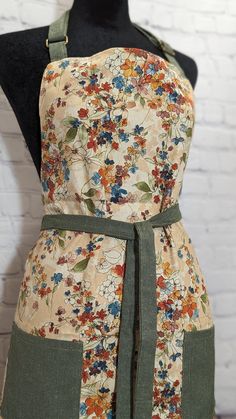 an apron on a mannequin with flowers and leaves