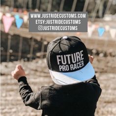 a young child wearing a hat with the words future pro racer on it's back