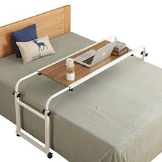 a bed with a laptop on top of it next to a pillow and some pillows