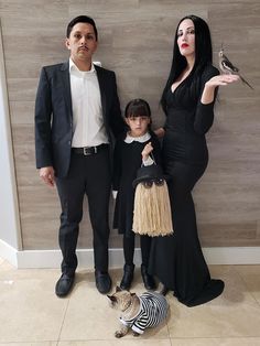 a man, woman and child dressed up for halloween with a bird on their shoulder