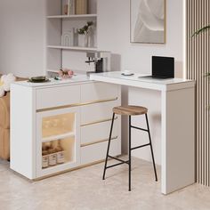 a white kitchen with a bar and stools in front of the counter top that has a laptop on it