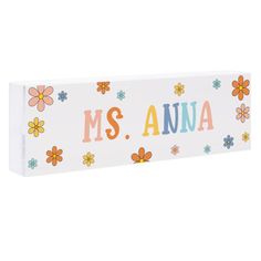 a wooden sign with flowers and the word ms anna on it's side