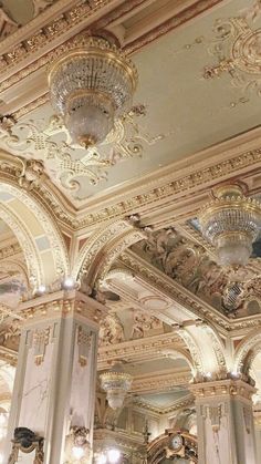 an ornately decorated room with chandeliers and mirrors on the ceiling, along with marble columns