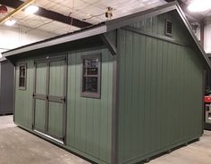 a small green building inside of a warehouse