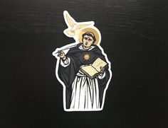 a sticker with an image of a saint holding a book and a bird on it