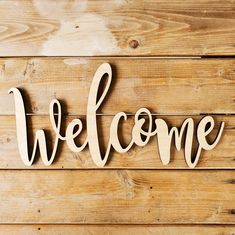 the word welcome is made out of wood on a wooden wall with planks in the background