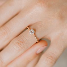 a woman's hand with a diamond ring on it