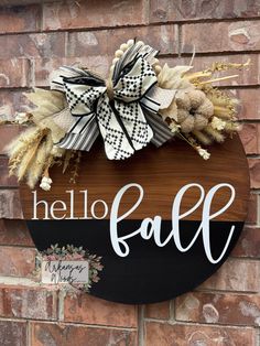 a sign that says hello fall hanging on a brick wall