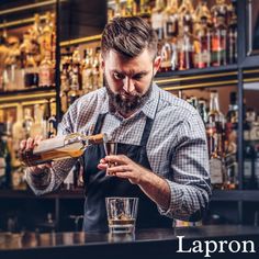 a man pouring liquor into a glass at a bar