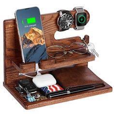 a wooden docking station with an iphone, watch and other items in it on a white background