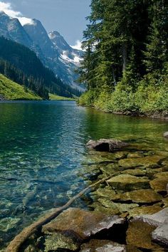 the water is crystal green and there are mountains in the background