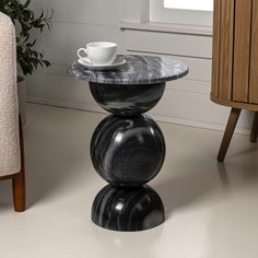 a black marble table with a cup on top