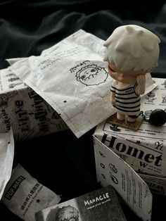 a small figurine is sitting on top of some paper bags and other items