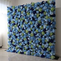 a large blue and green flowered wall hanging on the side of a white wall