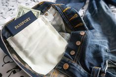 a passport sticking out of the back pocket of a pair of jeans with money in it