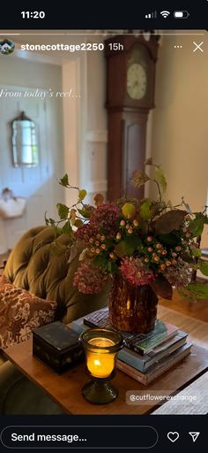 a vase filled with flowers sitting on top of a wooden table next to a candle