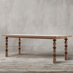 a wooden bench sitting on top of a hard wood floor next to a cement wall