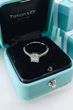 a diamond ring sits in a blue box