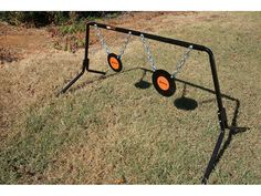 a black metal swing set with two orange wheels