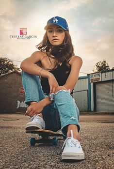 a young woman sitting on top of a skateboard