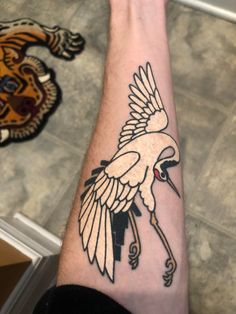 a person with a tattoo on their arm that has an image of a bird on it