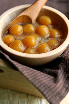 a wooden bowl filled with eggs on top of a table