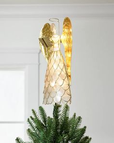 an angel ornament hanging from a christmas tree