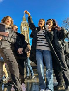 three women standing in front of the big ben clock tower holding coffee cups and taking a selfie