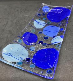 a blue and white glass plate sitting on top of a table next to a wall