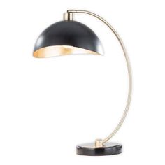 a black and gold desk lamp on a white background, with the light turned off