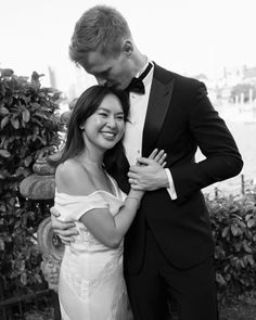 a man in a tuxedo is hugging a woman