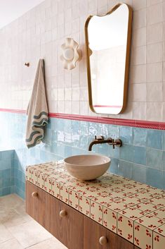 a bowl sink sitting on top of a counter next to a mirror and towel rack