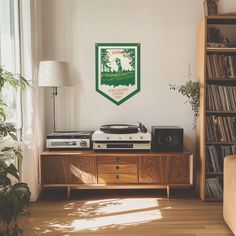 a record player sitting on top of a wooden cabinet in a living room next to a window