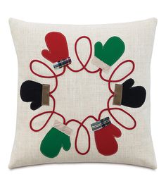 an embroidered pillow with mittens and gloves on it in the shape of a circle