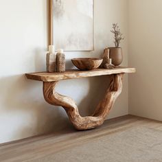 a wooden table sitting on top of a hard wood floor next to a white wall