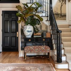 a plant in a vase sitting on top of a table next to a stair case