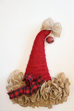 a red hat with burlocks and bows is hanging on the wall