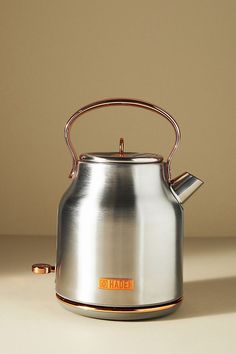 a silver tea kettle sitting on top of a table