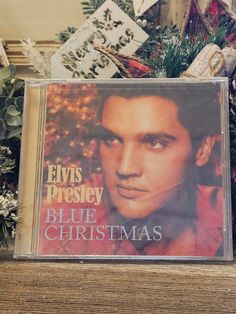 elvis presley blue christmas cd sitting on top of a wooden shelf