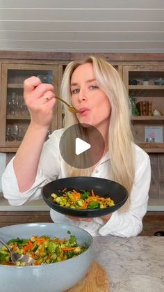 a woman is eating food from a bowl