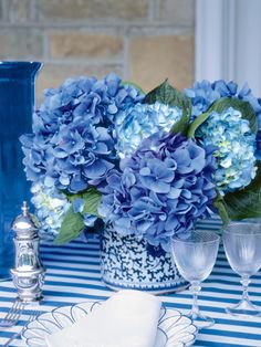 blue flowers are in vases on a table