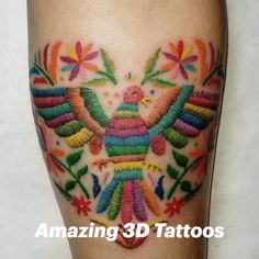 colorful tattoo on the leg of a person with an eagle and flowers in the background