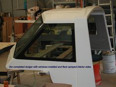 a white car in a garage next to some shelves