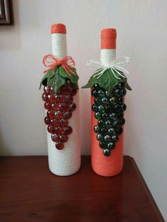 two wine bottles decorated with grapes and leaves