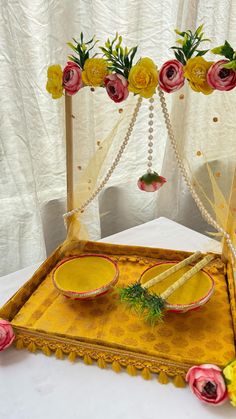 a tray with flowers on it sitting on a table next to two plates and napkins